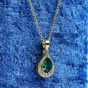A Refined Gold Necklace With A Teardrop Design, Featuring A Sparkling Colored Gemstone Encircled By Brilliant Diamonds